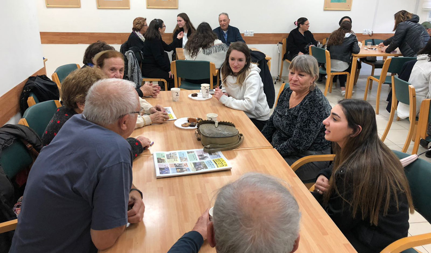 תלמידות תיכון קרית חיים וניצולי השואה במועדון קפה בריטניה (צילום: תיכון קרית חיים)