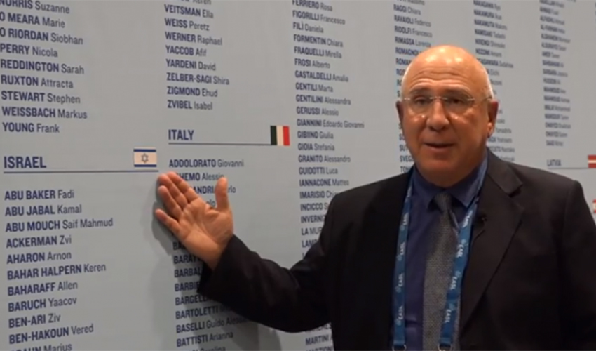 פרופ' אלי צוקרמן ודגל ישראל בכנס בפריז (צילום: באדיבות אתר "דוקטורס אונלי")