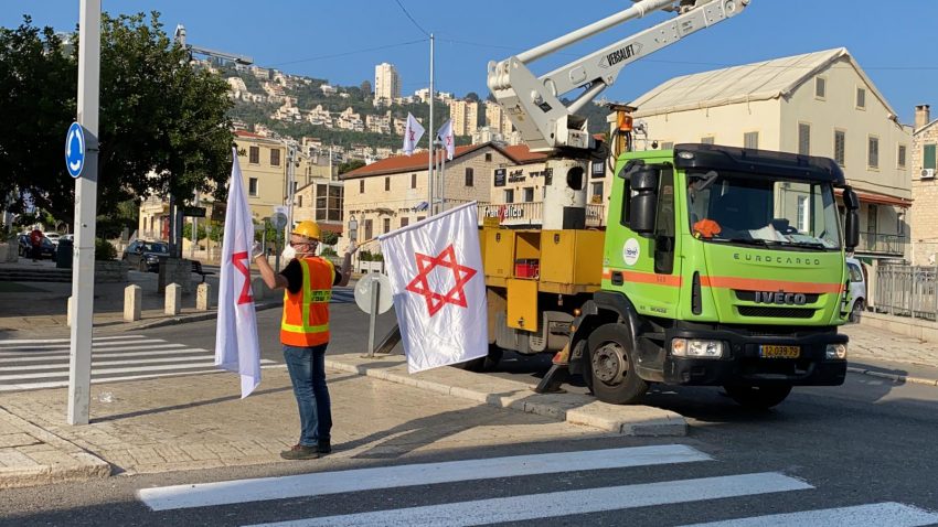 עובדי עיריית חיפה תולים דגלים של מד"א (צילום: ראובן כהן, דוברות עיריית חיפה)