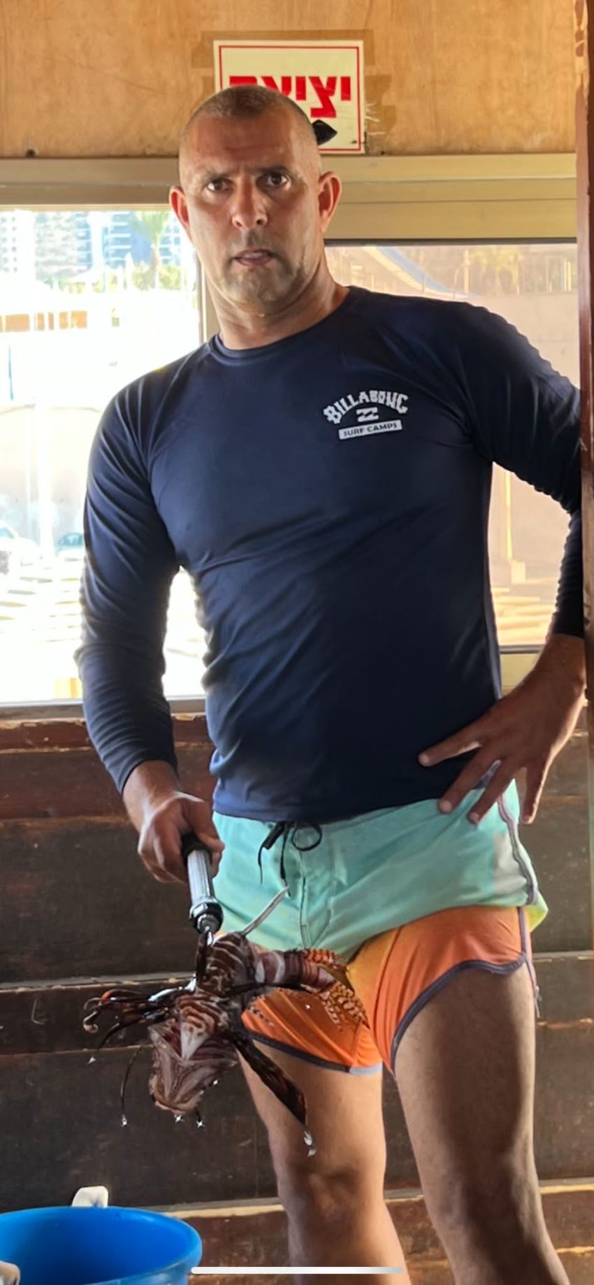 המציל יוסף חרדון מחזיק את דג הזהרון (צילום: דוברות עיריית חיפה)