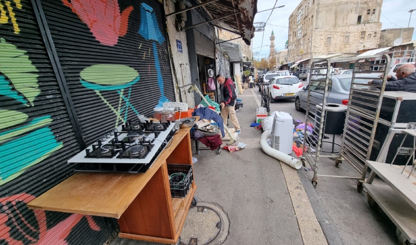 סחורה על המדרכה ועל הכביש בשוק הפשפשים