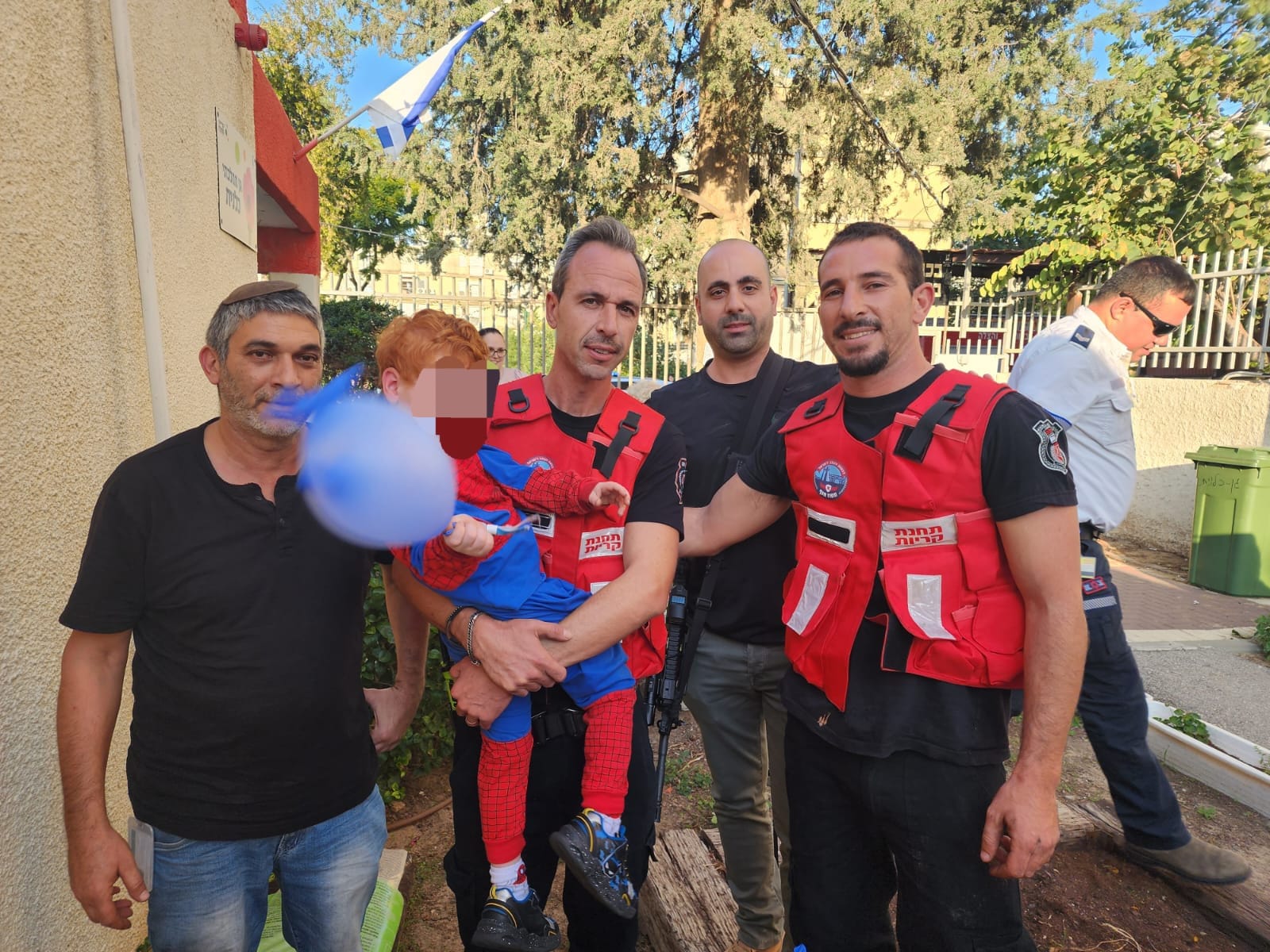 לוחמי האש עם הילד שחולץ (צילום: דוברות שירותי הכבאות וההצלה)