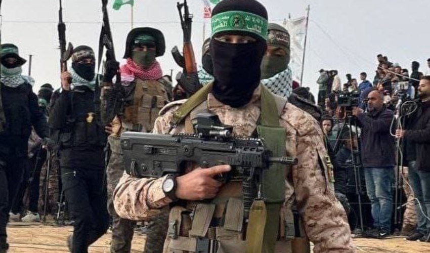 מחבל חמאס עם נשק ישראלי מסוג תבור. מאחור: "בלתי מעורבים" (צילום: ערוצים ערביים)