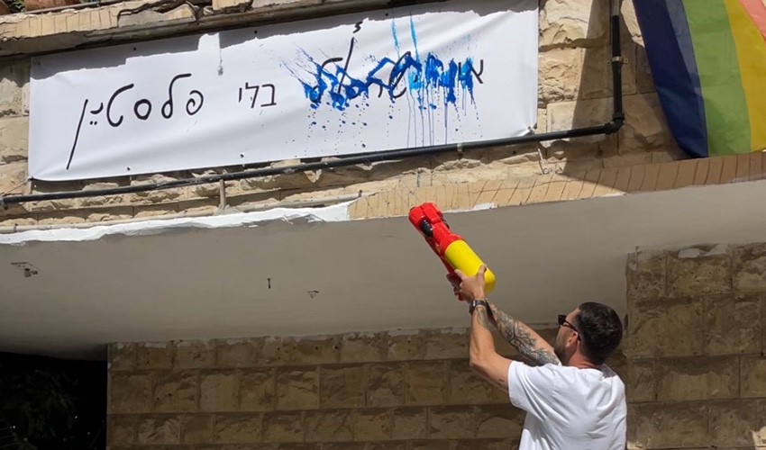 קיריל קארטניק מתיז צבע על השלט "אין ישראל בלי פלסטין"