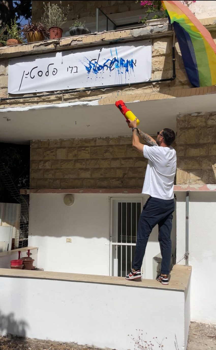 קיריל קארטניק מתיז צבע על השלט "אין ישראל בלי פלסטין"