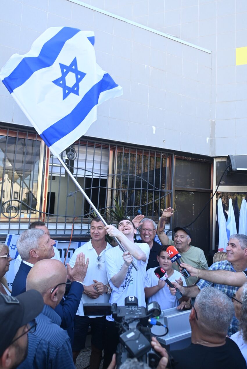 מקסים הרקין עם דגל ישראל (צילום: דוברות עיריית קרית אתא)
