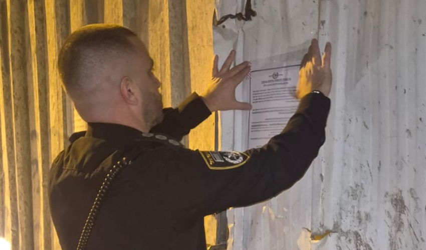 תליית צו הסגירה (צילום: דוברות המשטרה)